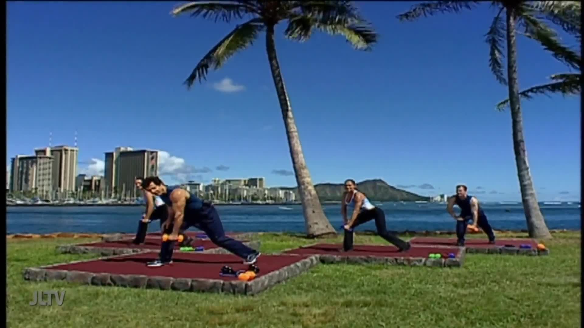 Three people are exercising on individual mats, each holding dumbbells. They're doing lunges with a waterfront view, likely filming for Jewish Life Television.
