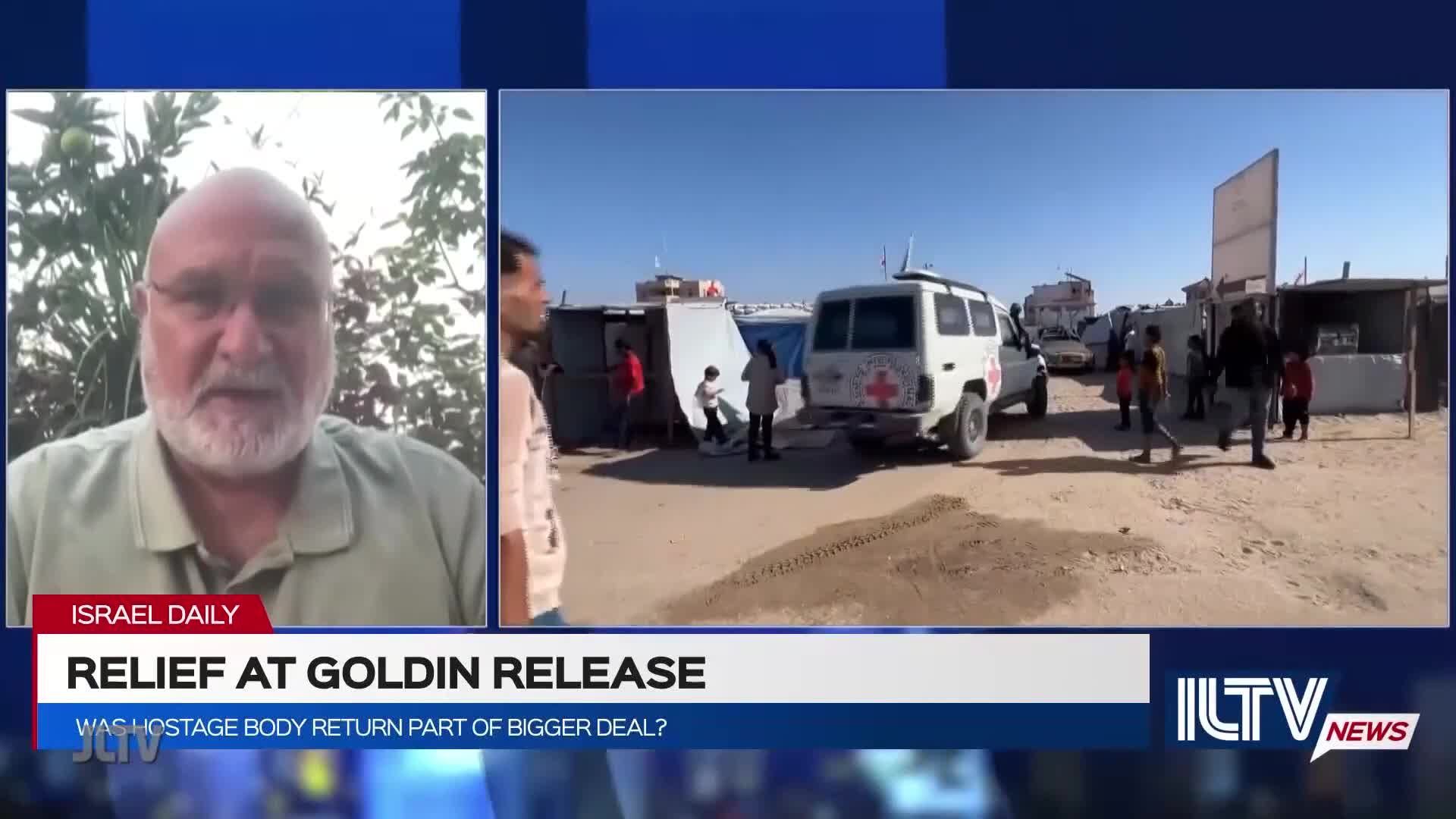 A man on Jewish Life Television discusses the release, while a Red Cross van sits parked nearby. Children and adults mill about in a dusty area with makeshift structures.
