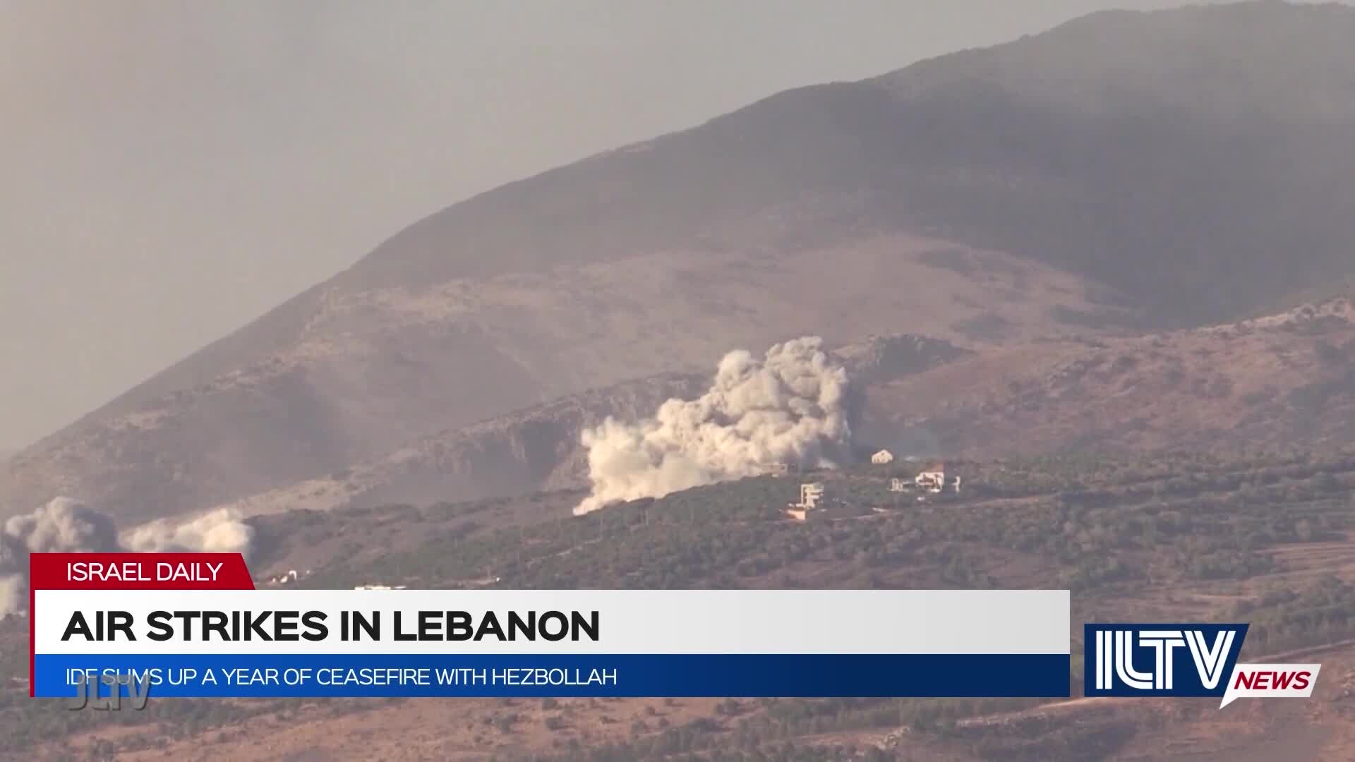 A large cloud of smoke billows upward from the hillside, obscuring the buildings below. The news ticker on Jewish Life Television reports on air strikes in Lebanon.
