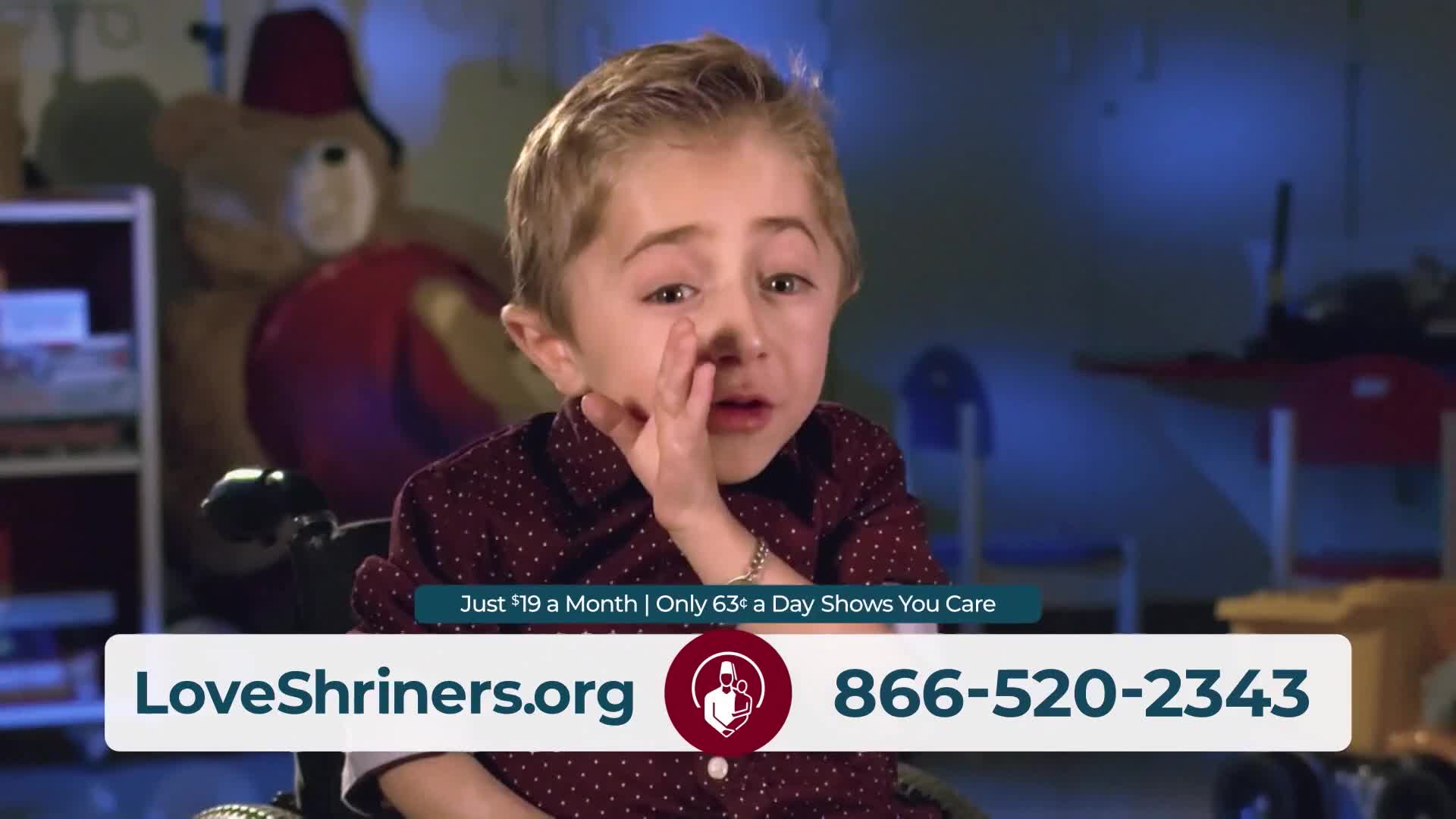 A young boy in a wheelchair looks directly at me, his hand near his face. A graphic overlay displays a website and phone number for Shriners Hospitals for Children.
