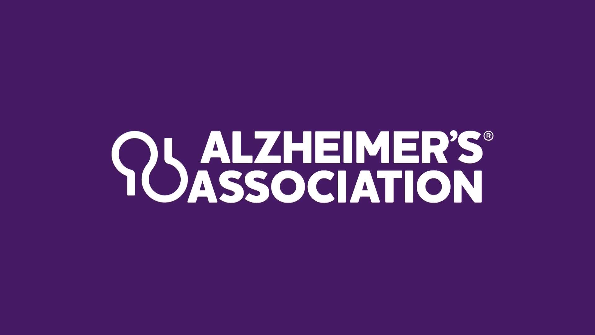 The Alzheimer's Association logo appears on a deep purple background. A stylized white symbol, resembling two linked loops, sits to the left of the white text "ALZHEIMER'S ASSOCIATION."