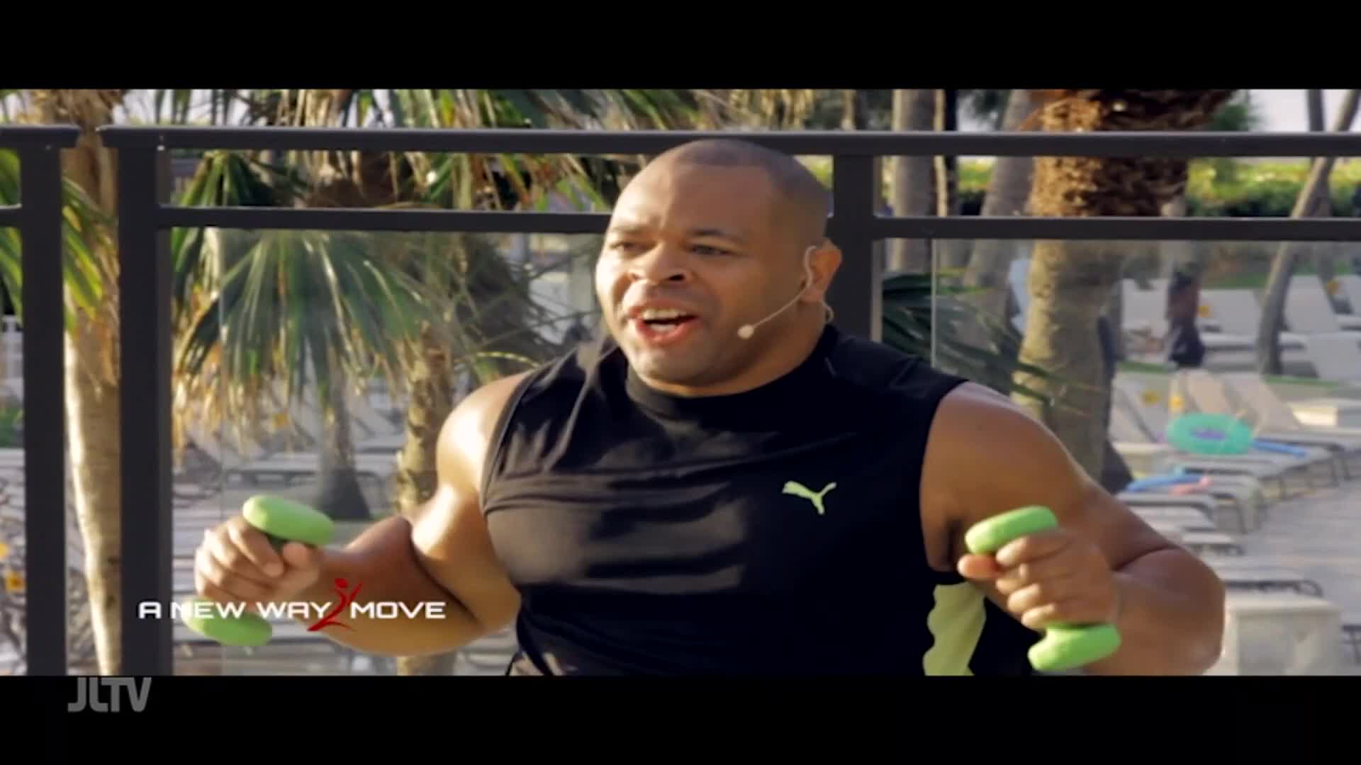 A man with a headset is lifting light green dumbbells, his muscles tensing with each movement. The background suggests a sunny outdoor setting, perhaps a resort, with palm trees and lounge chairs visible.