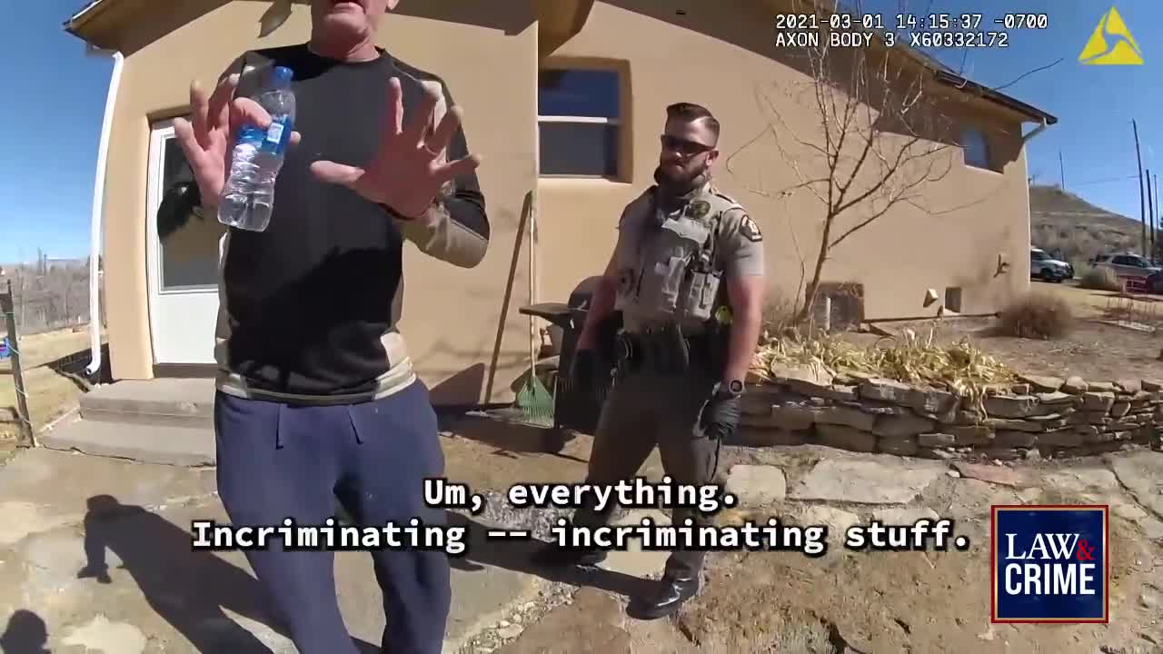 A man holds up a water bottle, gesturing emphatically toward a uniformed officer. The man's words, "Incriminating stuff," appear on the screen, as the Law & Crime logo is visible.
