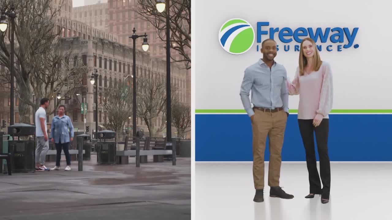Two people stand in a wet plaza, talking near some trash cans.  On the other side, two smiling people pose in front of a "Freeway Insurance" backdrop.
