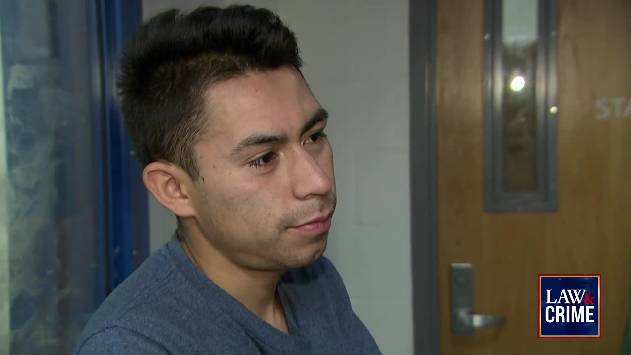 A young man in a blue shirt looks to his left, his expression serious. The "Law & Crime" logo is visible in the corner, and he appears to be in a hallway.
