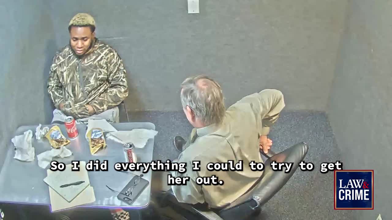 A man in a camouflage jacket sits across from another, who leans forward in his chair.  The scene appears to be an interrogation room, as indicated by the Law & Crime logo.
