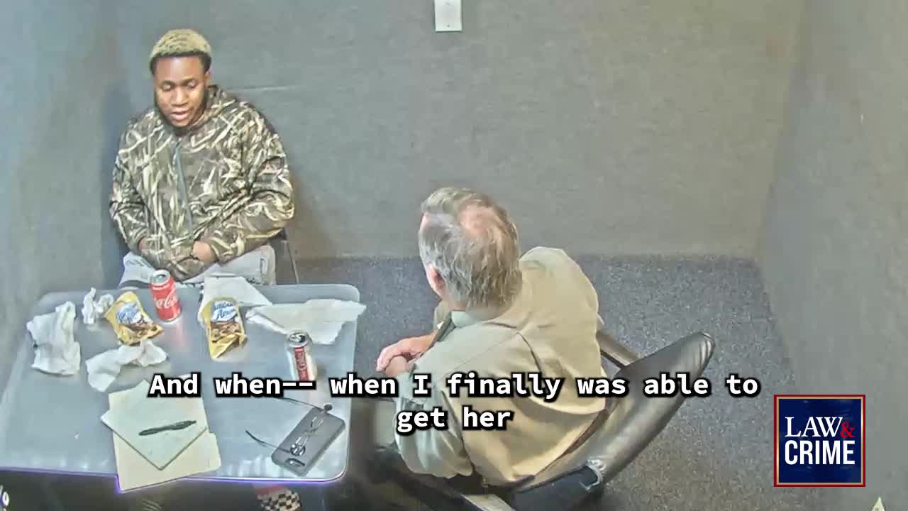 A man in camouflage sits across from another man in a tan shirt, both in a stark, gray room.  The man in camouflage speaks, and the Law & Crime logo is visible in the corner.
