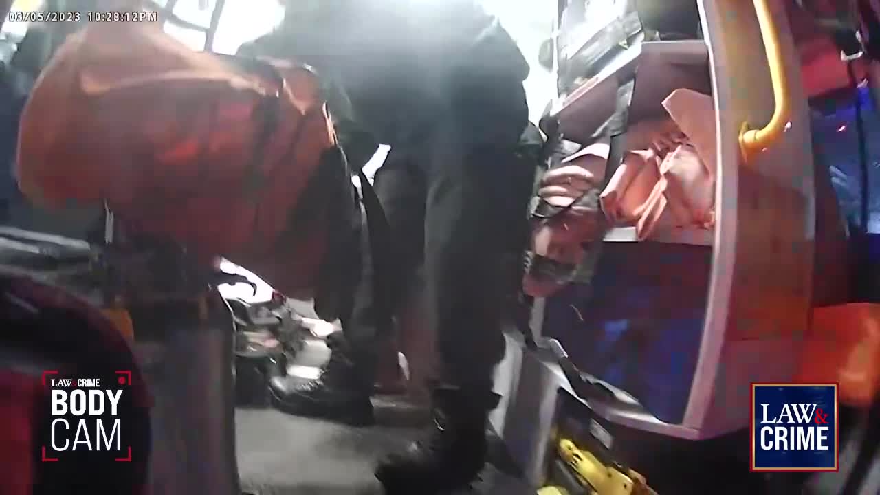 Inside a vehicle, a person in dark clothing is holding a large orange bag. The "Law & Crime" logo is visible, suggesting this is body camera footage from a scene in the United States.
