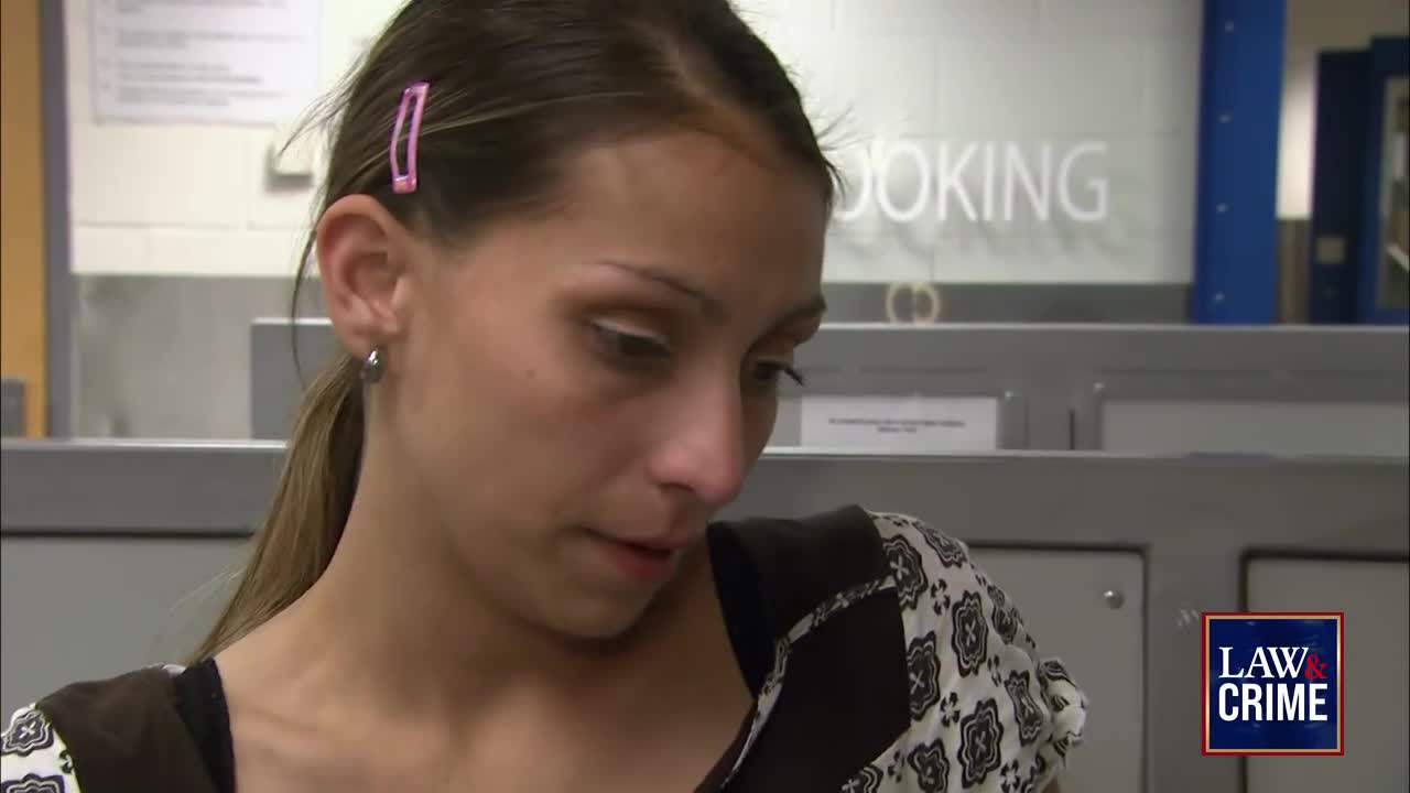 A woman with a pink barrette looks down, her expression somber. The "Law & Crime" logo is visible, suggesting a broadcast related to legal proceedings.
