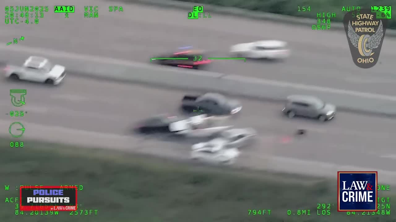 A black car with flashing lights is speeding down the highway, pursued by other vehicles. The Ohio State Highway Patrol logo is visible, and the Law & Crime logo suggests a live broadcast of a police pursuit.
