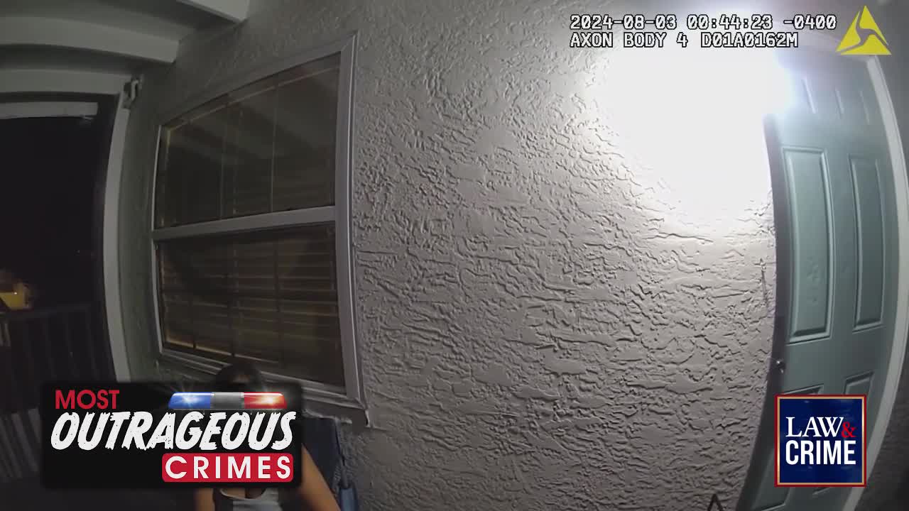 A woman sits on a porch, illuminated by a bright light. The timestamp on the body camera indicates it's early morning in the United States.