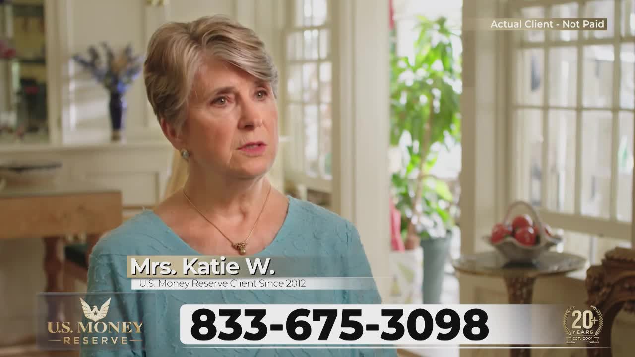 A woman with short gray hair speaks directly to the camera. A phone number flashes across the bottom of the screen.