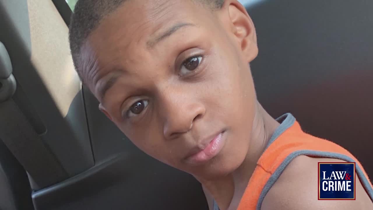 A young boy in an orange tank top looks directly at the camera. A Law & Crime logo appears in the lower right corner.