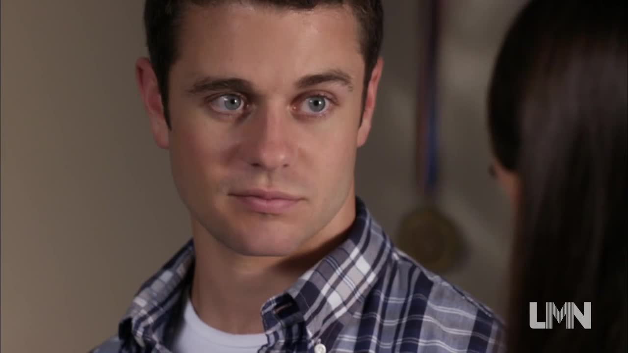 The man in the plaid shirt stares intently, his blue eyes focused on someone just off-screen. The Lifetime Movies logo in the corner suggests this is a tense moment from a made-for-TV drama.
