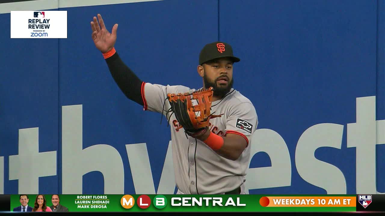 A San Francisco Giants player, glove in hand, raises his arm toward the blue wall. The MLB Network logo is visible at the bottom of the screen.

