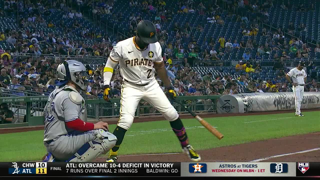 The Pirates batter, number 7, is mid-swing, the bat arcing down. The catcher is crouched low, watching the ball's trajectory.
