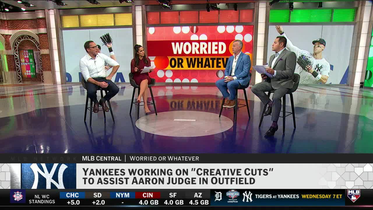 Four people sit on stools, holding papers, on a brightly lit set. The MLB Network logo and a headline about the Yankees are displayed on the screen below.
