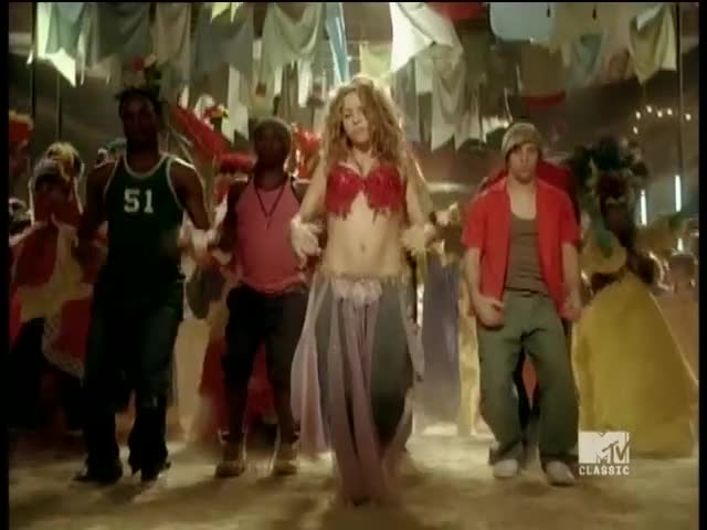 A woman in a red bra and belly dancer skirt leads a group of dancers, all moving in unison. The MTV Classic logo in the corner confirms this is a music video from the United States.
