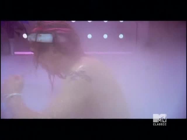 A person with wet, red hair is moving around in a hazy, purple-lit space. The MTV Classic logo confirms this is a scene from a music video.
