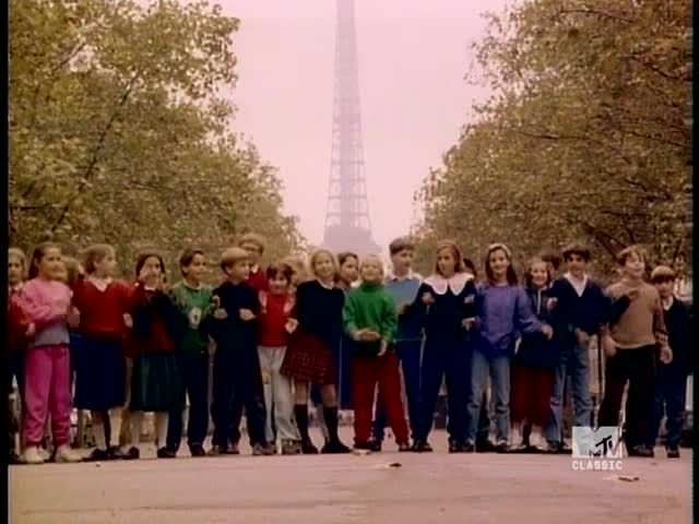A group of kids, arm in arm, is walking toward the camera. The Eiffel Tower looms in the background, and the MTV Classic logo is in the corner.
