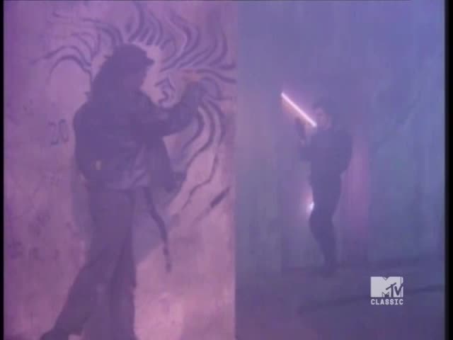 A figure sprays a mural on a wall, while another holds a glowing rod in a hazy, purple-lit space. The MTV Classic logo is in the corner, a reminder of the era.
