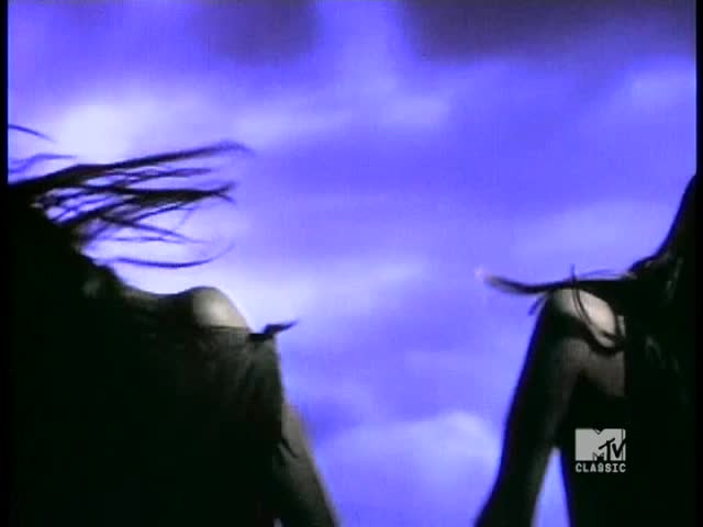 Silhouetted figures move against a hazy, purple backdrop, their long hair whipping in the air. The MTV Classic logo is visible in the corner.
