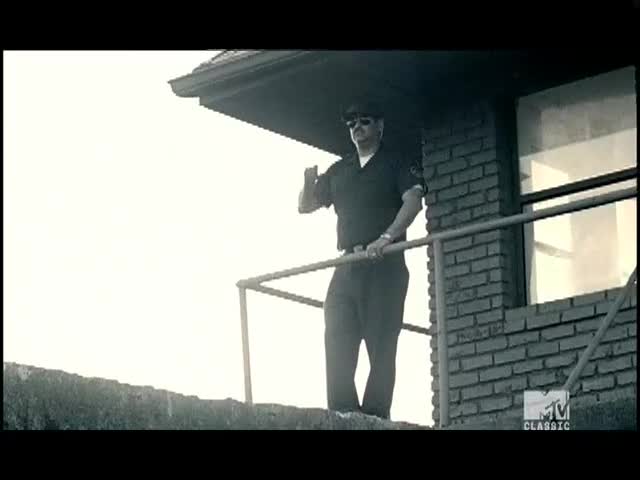 A man in a dark uniform stands on a ledge, gesturing with his right hand. The MTV Classic logo is visible in the corner.
