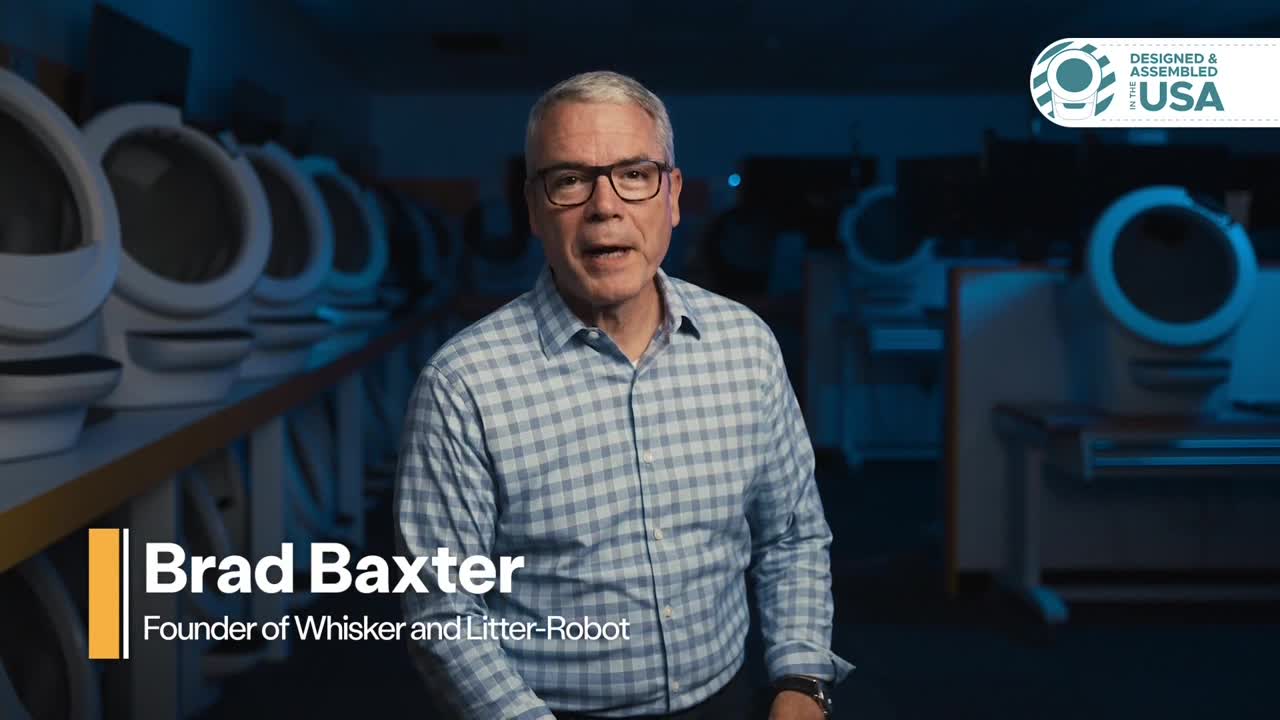 Brad Baxter, the founder of Whisker and Litter-Robot, stands in front of a row of what appear to be cat litter boxes. He's speaking directly to the camera, with a "Designed & Assembled in the USA" logo visible in the corner.
