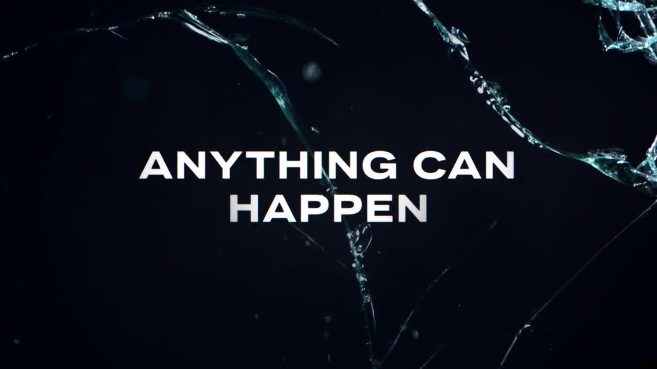 The words "ANYTHING CAN HAPPEN" are centered on a dark background. Jagged glass shards frame the text, hinting at a broken surface.
