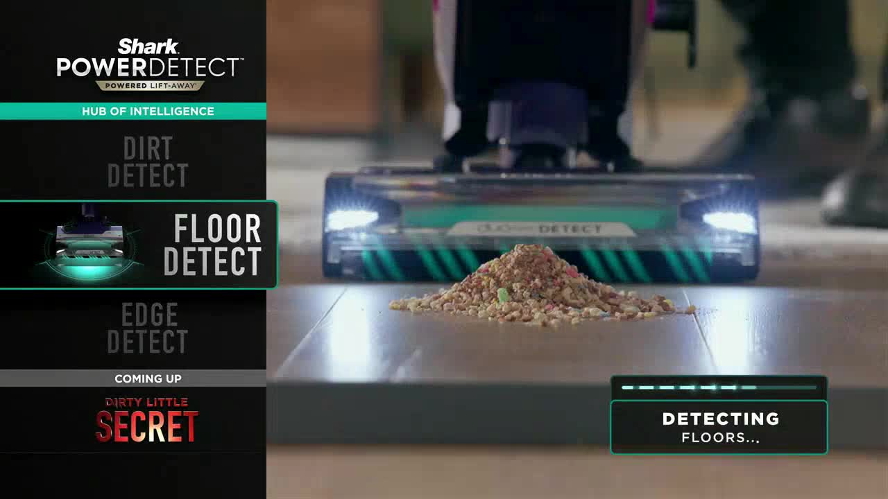 A vacuum cleaner, its lights on, hovers over a pile of debris on a wooden floor. The machine's display indicates it's "detecting floors."
