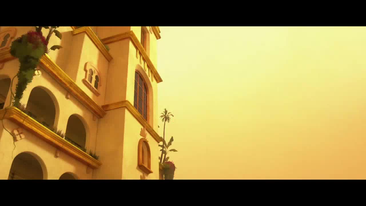 A sun-drenched building, likely in the United States, rises against a hazy sky. The structure's white walls and arched windows are adorned with plants, and a small palm tree grows from a pot.

