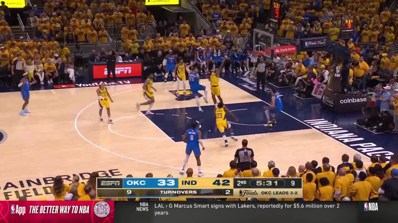 A player in blue leaps toward the basket, while a player in yellow and gold tries to defend. The crowd in the background is a sea of yellow.
