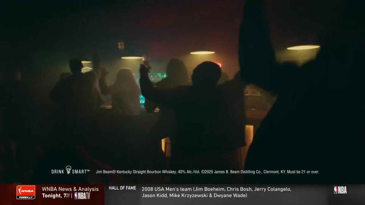 People are silhouetted in a dimly lit bar, raising glasses in a toast. The scene is part of an ad on NBA TV for Jim Beam bourbon.
