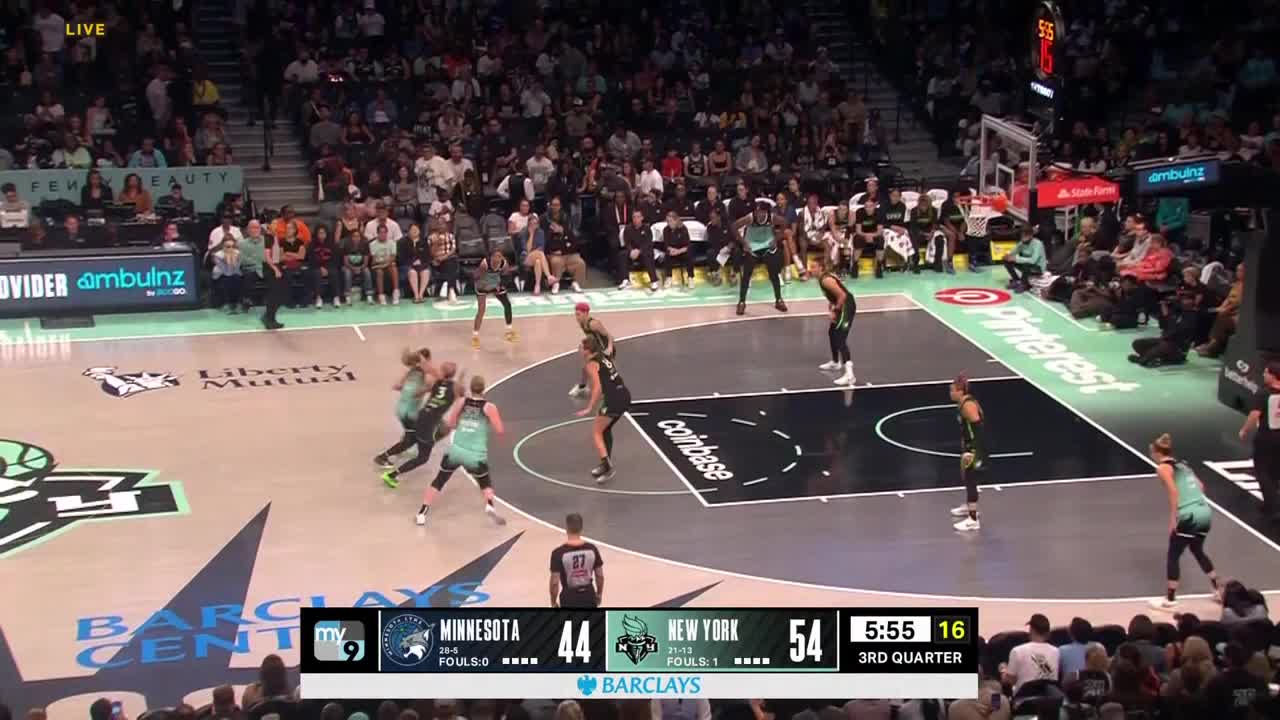 The New York team, in black and green, is on offense, with the ball moving up the court. The Minnesota team, in teal, is scrambling to defend.
