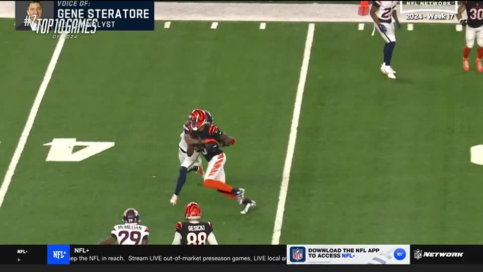 A Bengals player, in black and orange, is tightly held by a defender in blue. The runner is trying to keep the ball secure as he moves toward the sideline.
