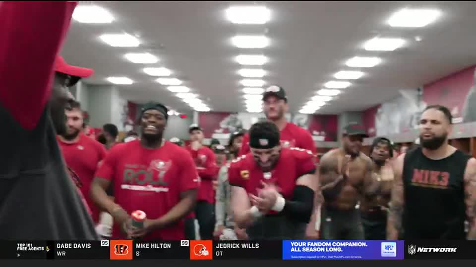 Players in red jerseys and hats are gathered in a locker room, clapping and smiling. The NFL Network logo is visible at the bottom of the screen.
