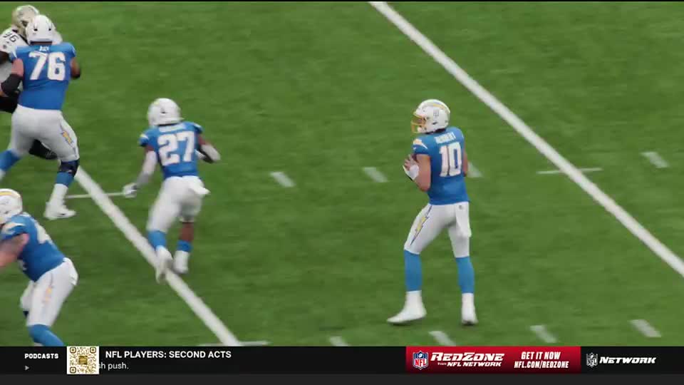 The quarterback, number 10, is in his throwing motion, looking downfield. Number 27 is running toward the sideline, and a lineman is blocking.

