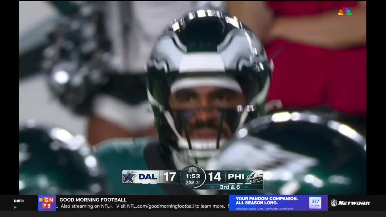 The Philadelphia Eagles quarterback, helmet on, is looking intently at something off-screen. The score graphic on NFL Network shows the Eagles trailing the Dallas Cowboys.
