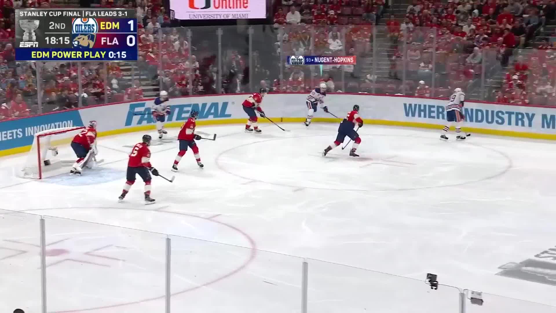 The Oilers are on a power play, with the puck carrier skating toward the blue line. Several Panthers players in red jerseys are positioned defensively near their own goal.
