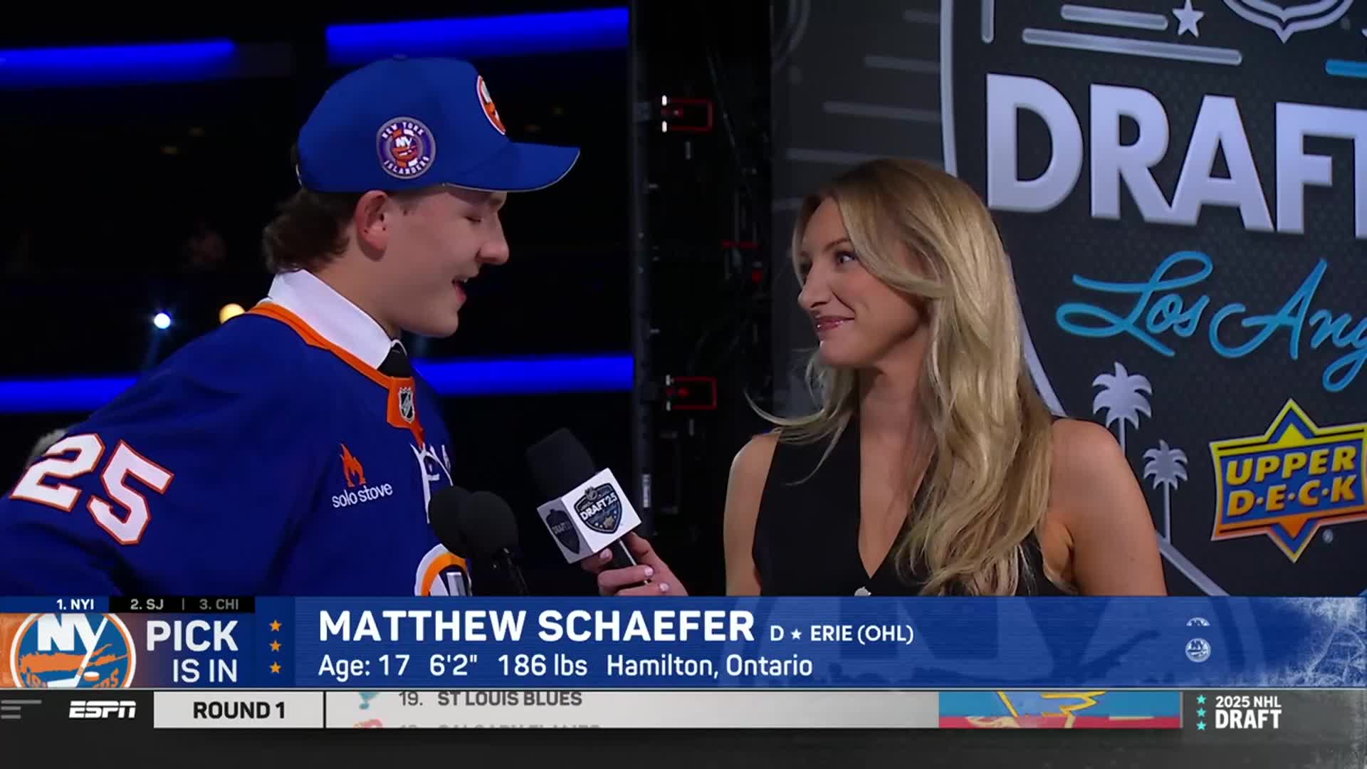 A young man in an Islanders jersey and cap is being interviewed on the NHL Network, holding a microphone. The interviewer, a woman with blonde hair, smiles as she listens.
