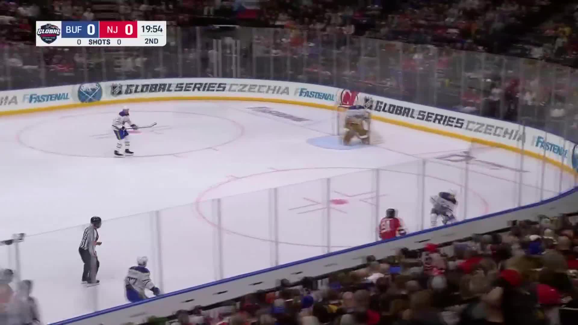 A player in blue skates toward the center ice, stick ready, while two red-clad players move closer to the net. The score is tied, late in the second period, as shown on the NHL Network broadcast.

