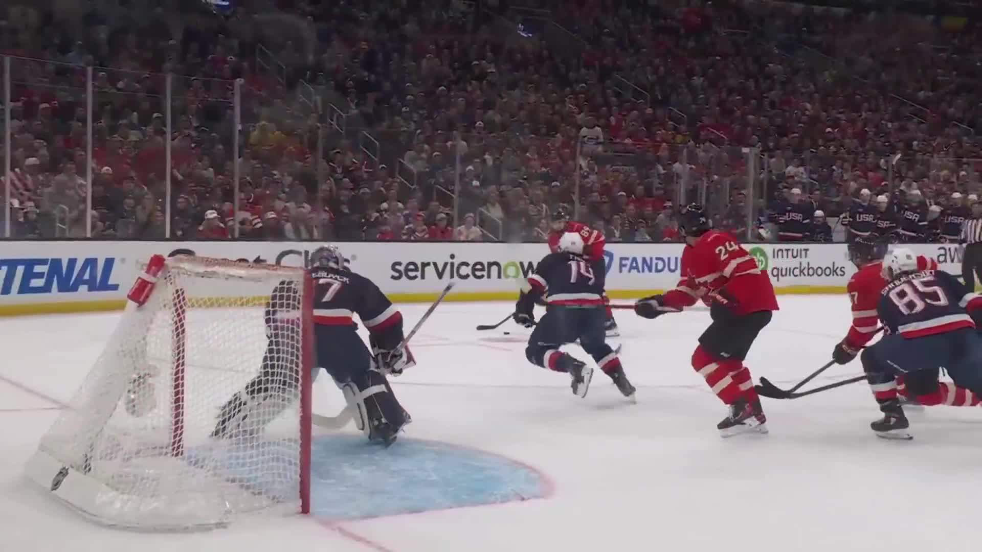 A player in a red jersey with the number 24 on his back skates toward the net, stick ready. The goalie, number 7, crouches low, anticipating the shot.