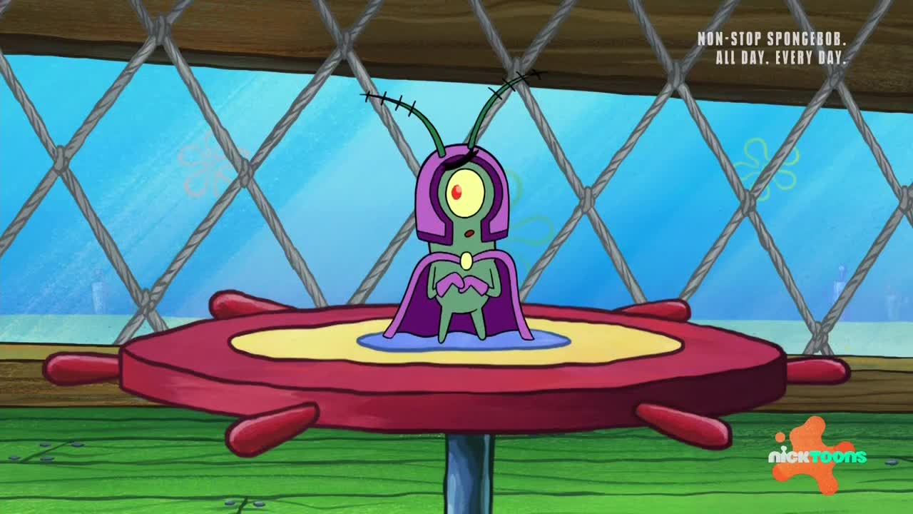 Plankton, in a purple cape and helmet, stands on a red, steering wheel-like platform. He's surrounded by a blue puddle, looking determined.
