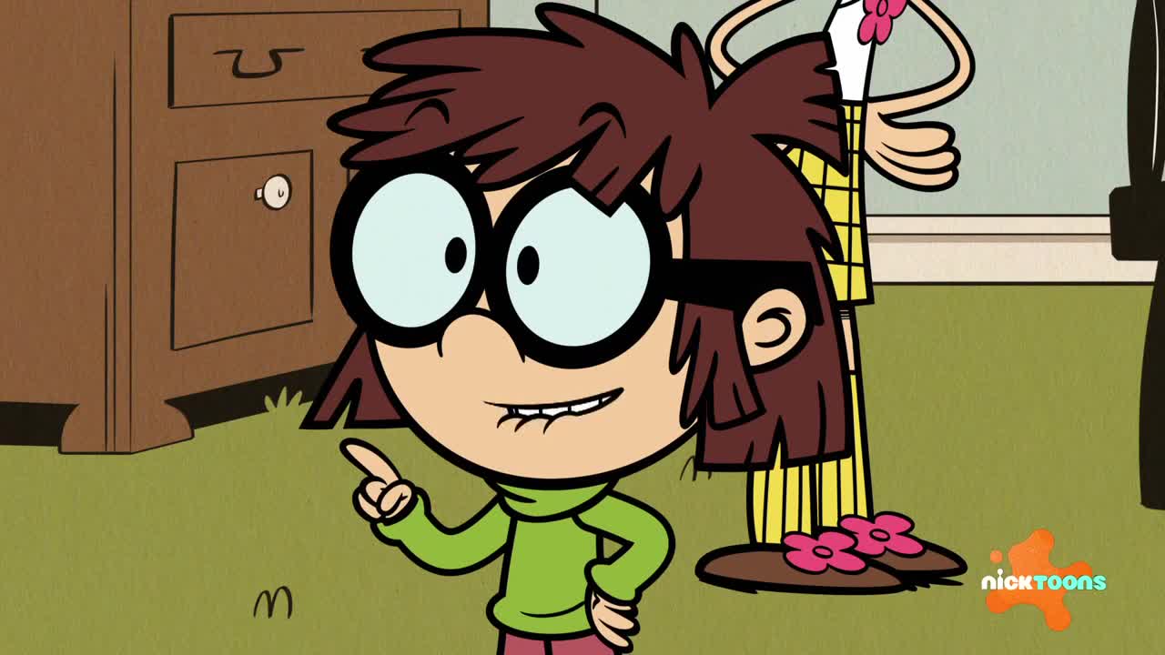 A young girl with large glasses points her finger forward, her mouth slightly open. Behind her, a person in yellow pajamas stands with their arms crossed.