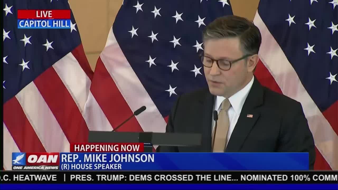 A man in a suit and tie speaks at a podium in front of the United States flag, as broadcast by One America News Network. The chyron identifies him as Representative Mike Johnson, the House Speaker.
