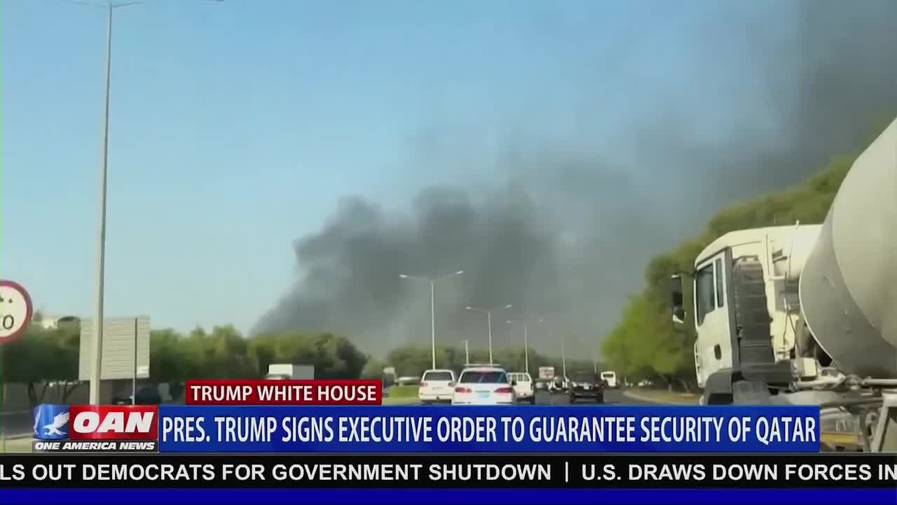 A thick, dark plume of smoke billows in the distance, obscuring the sky. Cars and trucks drive along the highway, while a news ticker from One America News Network reports on a presidential order.

