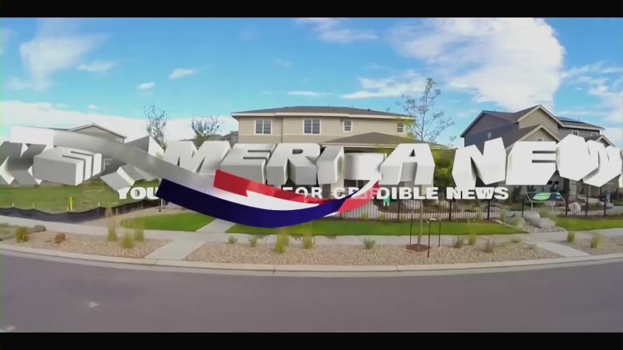 The words "AMERICA NEWS" in 3D block letters are partially obscuring a residential street scene. A stylized red, white, and blue banner is arcing across the bottom of the screen.
