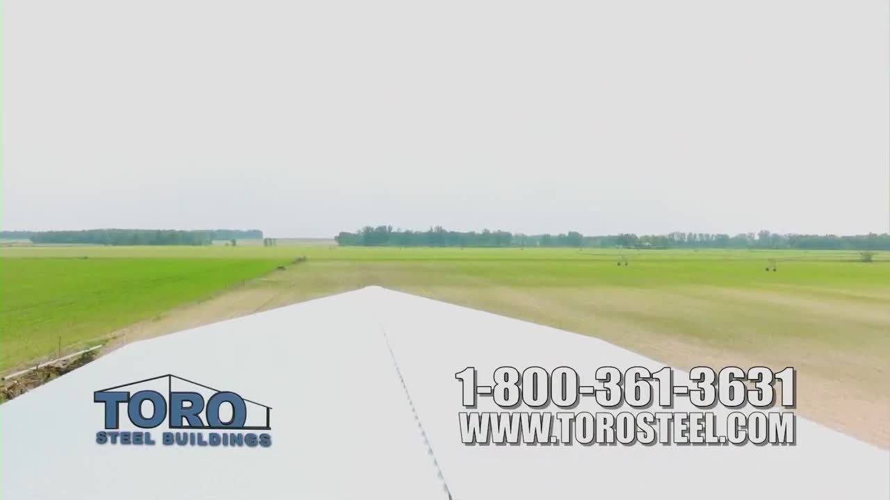 A white roof angles down, with a green field stretching out behind it. The logo for Toro Steel Buildings and a phone number are plastered across the bottom of the screen, likely a commercial on One America News Network.
