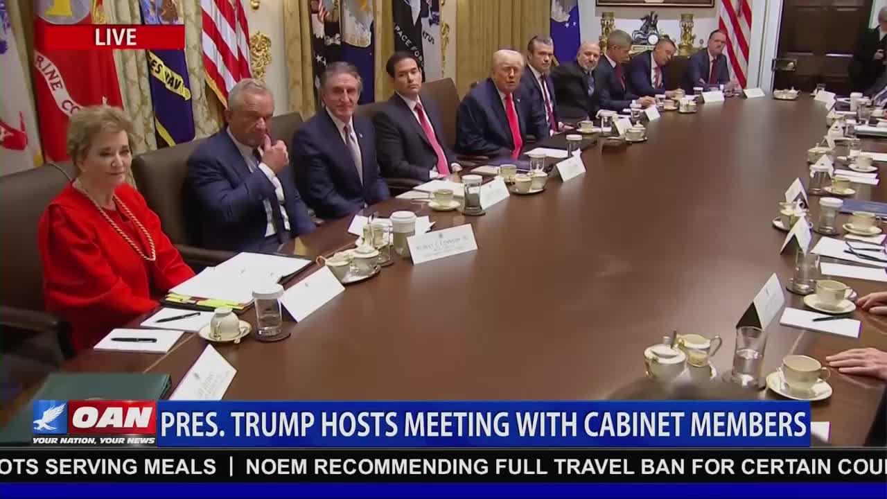 A group of people, including Donald Trump, are seated around a large table, presumably in a meeting. The One America News Network logo is visible at the bottom of the screen, indicating this is a live broadcast.

