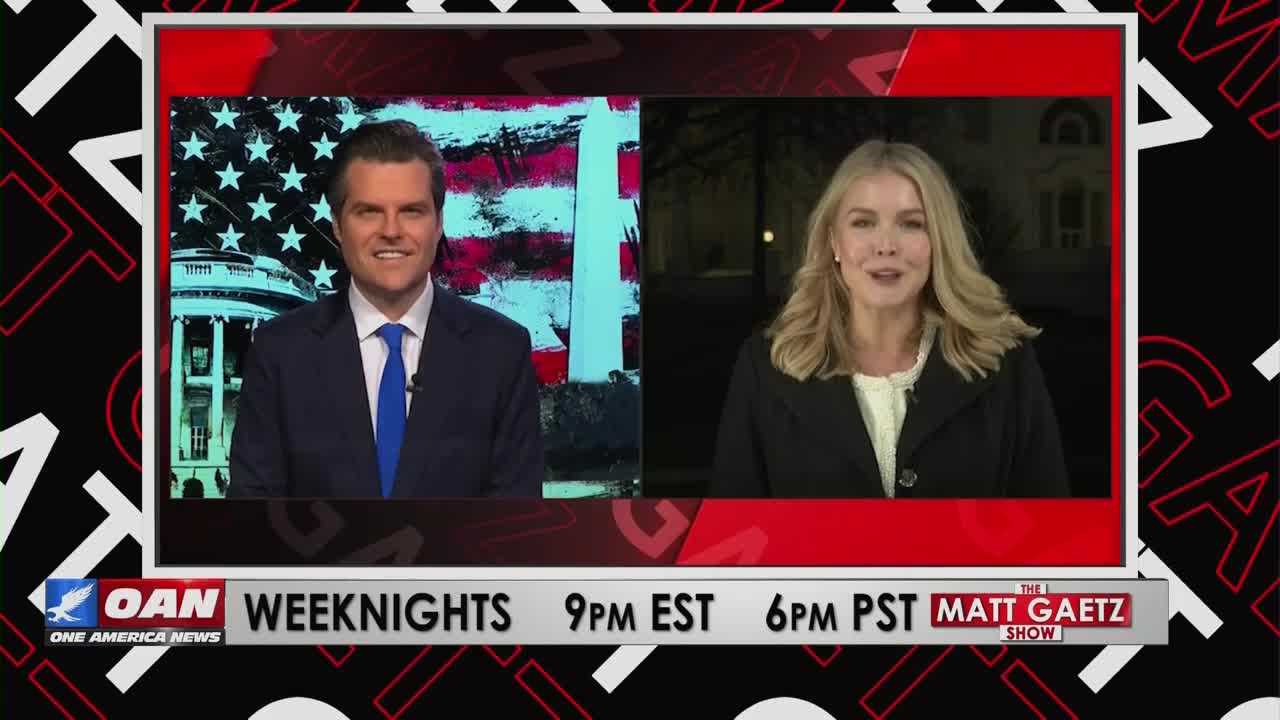 A man in a suit and tie smiles from a studio set with a U.S. flag backdrop, while a woman speaks from an outdoor location. The One America News Network logo and "The Matt Gaetz Show" title are visible on the screen.

